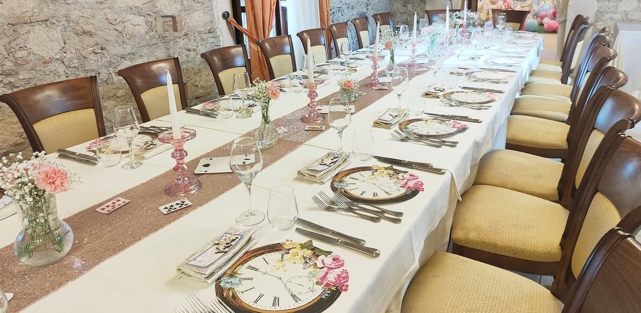 Tavola lunga con mise en place e dettagli rosa